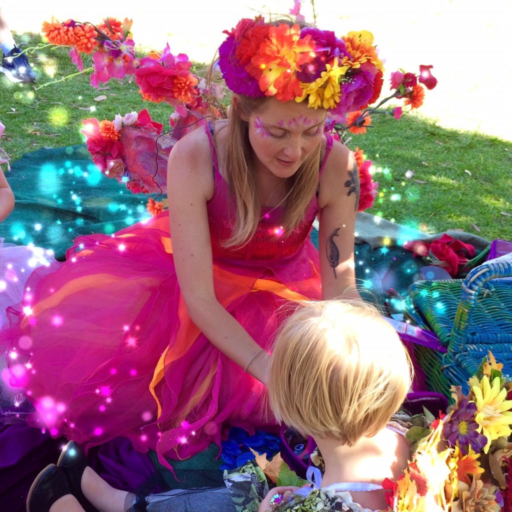 Made with Repix (http://repix.it) A woman in a pink dress with flowers on her head sitting on a blanket.
