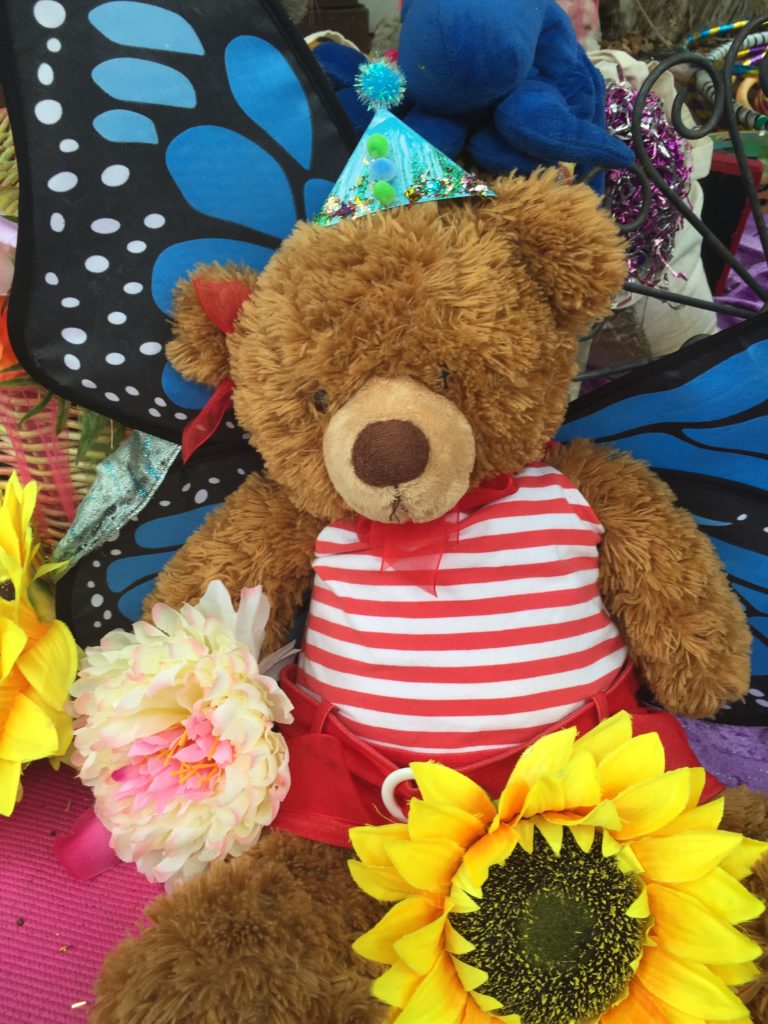 img_0971 A teddy bear with a hat and flowers.