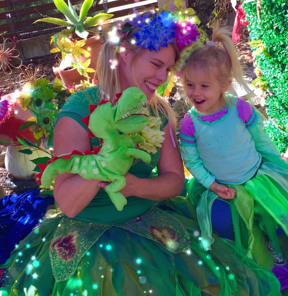 Made with Repix (http://repix.it) A woman dressed in a green dress with a little girl holding a stuffed animal.