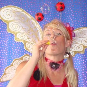 Disco Bubble A woman blowing bubbles while dressed as a ladybug.