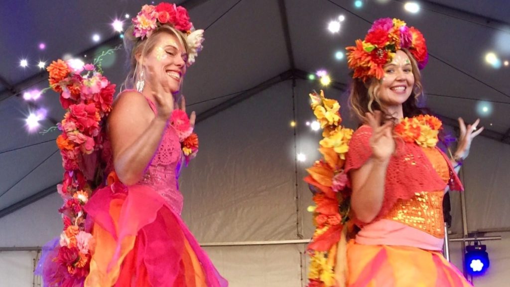 Made with Repix (http://repix.it) Two women dressed in colorful costumes on stage.