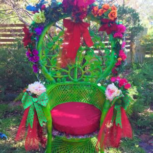 Green Christmas Chair A green wicker chair decorated with flowers and bows.