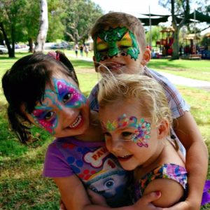 face Painting trio A group of kids with face paint.