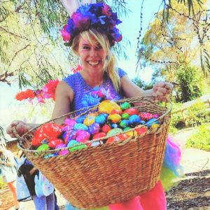 A woman holding a basket full of easter eggs.