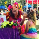 Face Painting A woman is helping a little girl get her face painted.