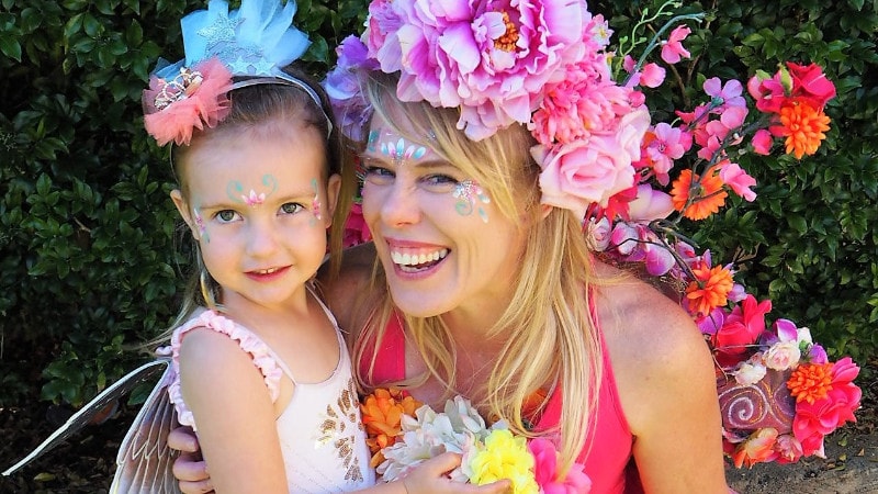 A woman and a little girl dressed up in flower crowns.