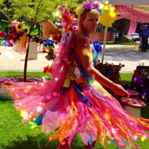 A woman dressed as a fairy in a colorful dress.