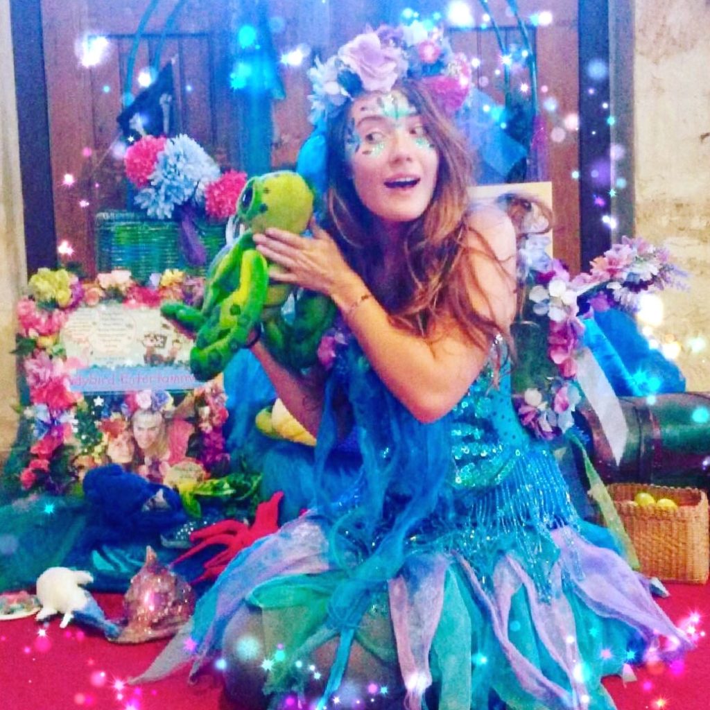 Made with Repix (http://repix.it) A woman dressed as a mermaid holding a stuffed animal.