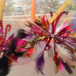 A group of colorful feathers hanging from a window.