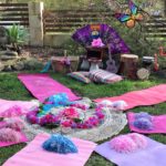 A backyard party with pink and purple decorations.